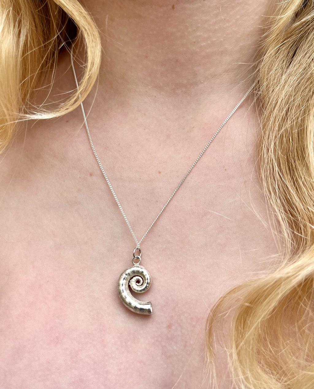 Chunky silver spiral shell necklace.