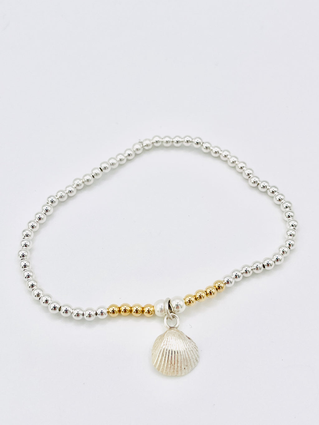 Silver and gold beaded bracelet with scallop shell.