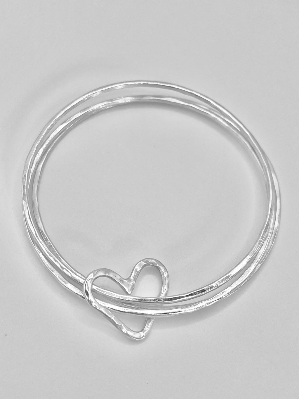 Triple stacking bangle with joining heart.